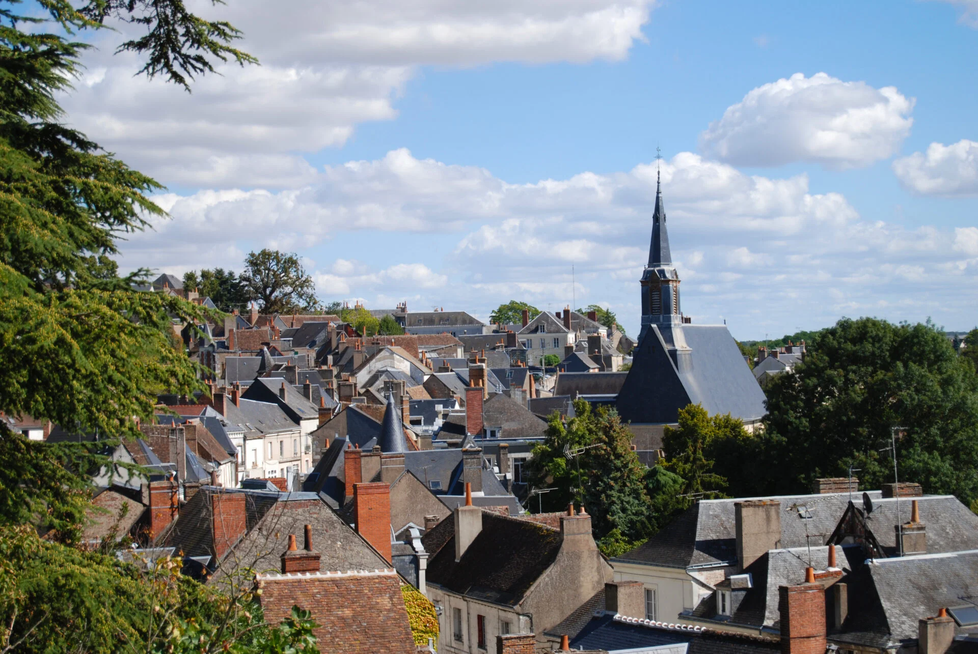 Vue aérienne d'un village européen avec toits en ardoise, ruelles et une église élevée au centre. Correspond aux étapes d'un déménagement d'entreprise dans le cadre d'un guide.